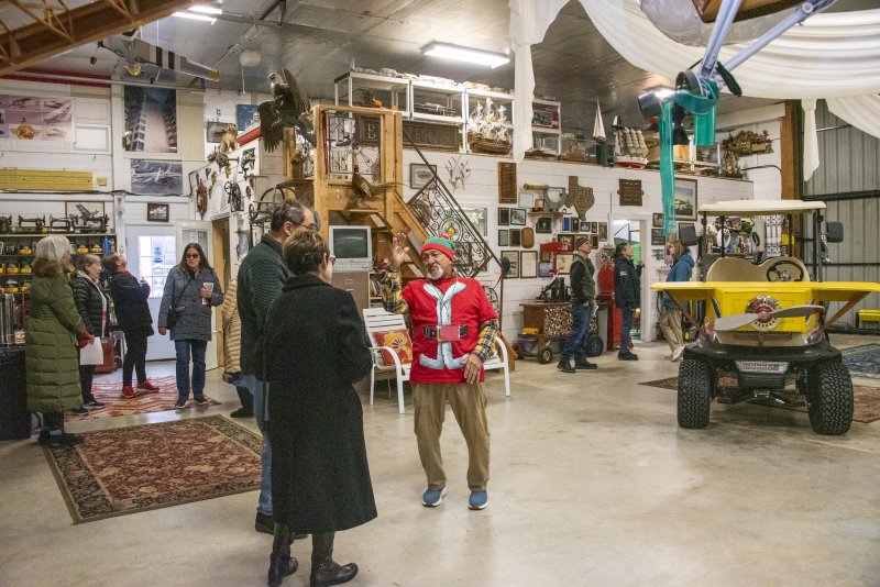 John Chirtea, dressed as an elf, tells guests about his history of flight and multiple collections.